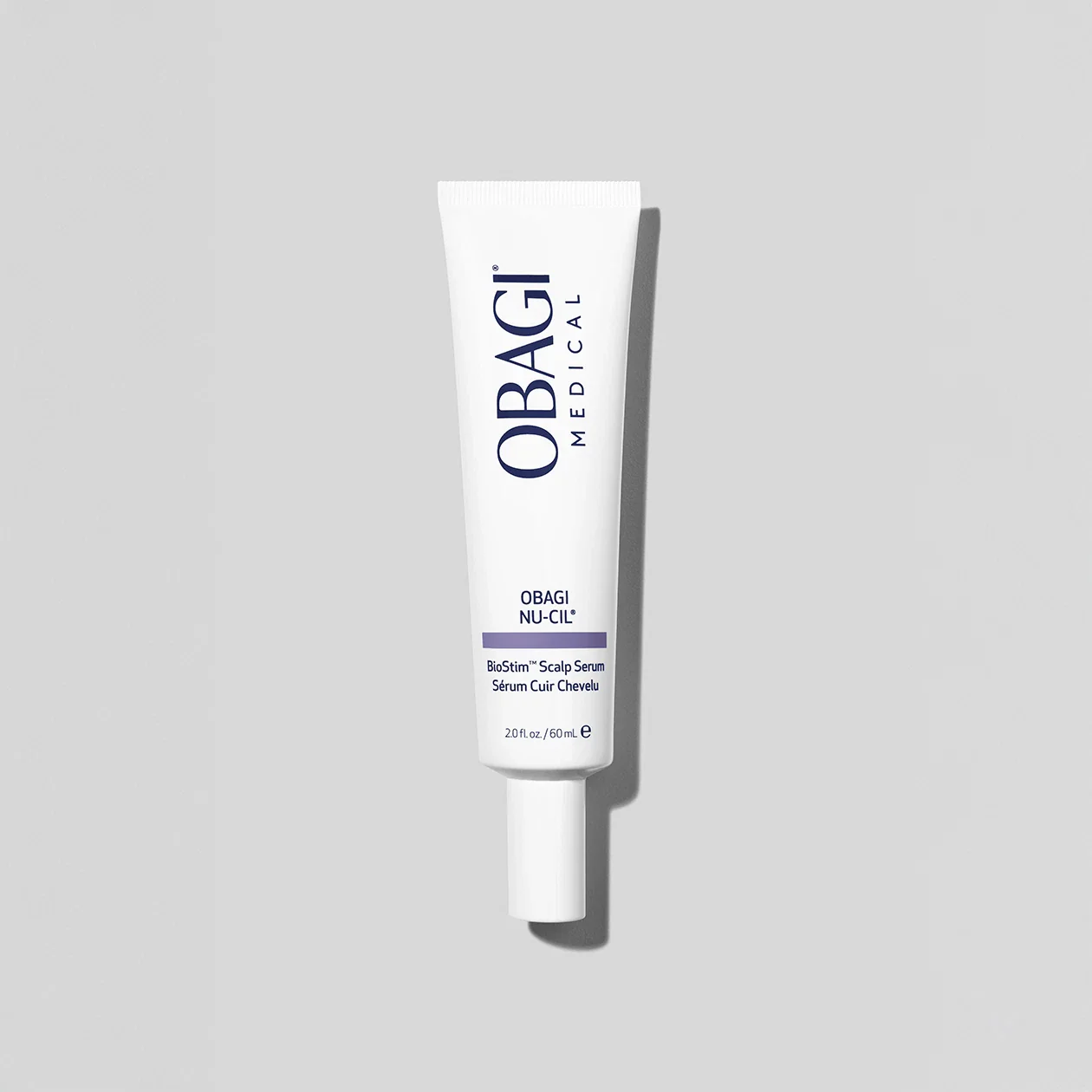 White Obagi Medical product tube on a gray background with a shadow, likely scalp serum